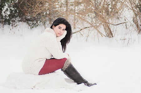 Woman In White Sweater Sitting Near Grass During Winter Season thumbnail