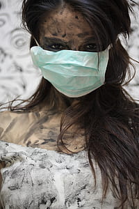 woman in white top covering her mouth with face mask thumbnail
