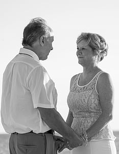 greyscale photography of man and woman facing and holding hands on wide field thumbnail