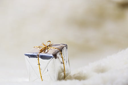 selective focus photography of silver gift box on white textile thumbnail