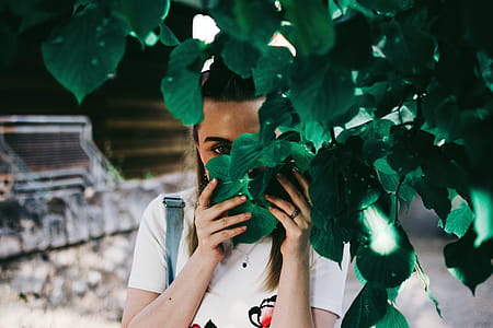 Woman Holding Leaves Covering Her Face thumbnail