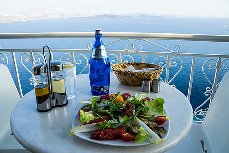 photo of table with vegetable salad near blue bottle, basket, and cruets thumbnail