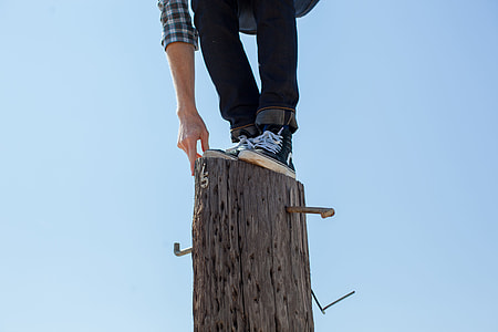person on black pants standing in brown wooden log thumbnail