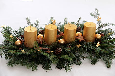 closeup photo of four pillar candles with green leaves thumbnail