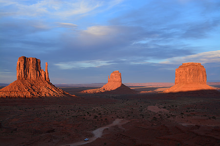 white vehicle passing through Monument Valley in Arizona during daytime photo thumbnail
