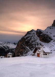 house beside rock formation covered with snow thumbnail