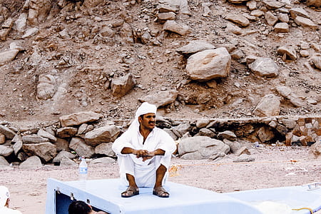 man in white thobe on vehicle roof thumbnail