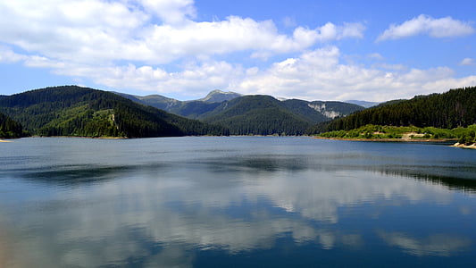 mountain beside body of water during daytime thumbnail