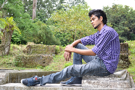 man sitting on concrete surface during daytime thumbnail