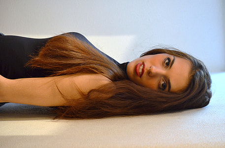 woman wearing black sleeveless top leaning on white wall thumbnail