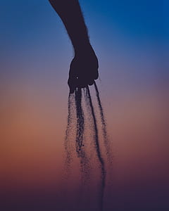 silhouette photo of person holding sand thumbnail
