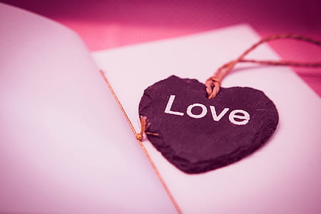 selective focus photography of black stone Love printed pendant on white paper sheet thumbnail