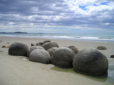 black rocks beside ocean during daytime thumbnail