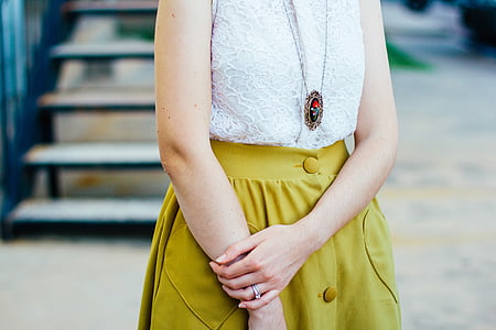 person wearing white lace top standing beside staircase thumbnail