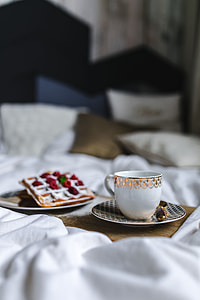Breakfast in bed - waffles with raspberries and cup of coffee on the tray thumbnail