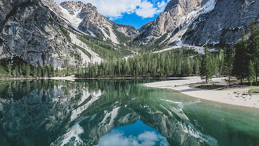 snow coated mountain reflecting on body of water thumbnail