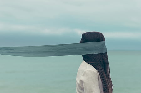 woman with white top and blue eye mask standing near ocean thumbnail