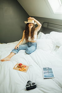 woman sitting on white mattress inside the room thumbnail