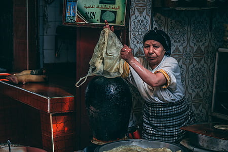 woman holding yellow and black bag beside black ceramic vase thumbnail