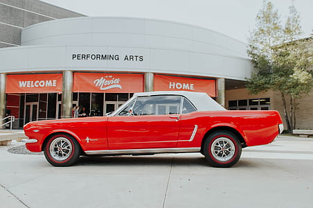 red Ford Mustang parked on front of Performing arts buildings thumbnail