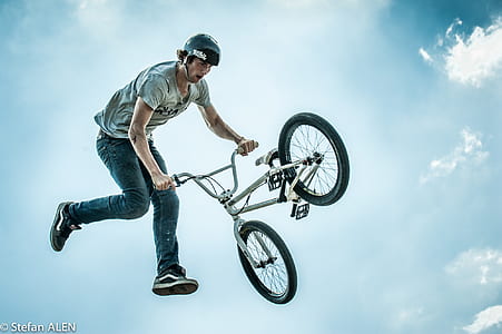 man ramping gray BMX bike thumbnail
