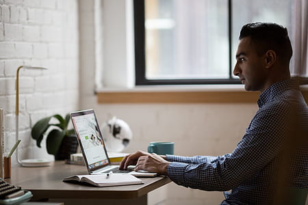 man wearing dress shirt in front of laptop computer thumbnail