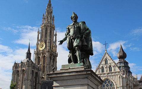 statue of man near cathedral during daytime thumbnail