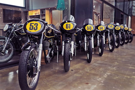 black and gray motorcycles parked on gray concrete pavement thumbnail