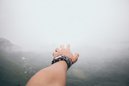 person wearing black watch and brown beaded bracelet thumbnail