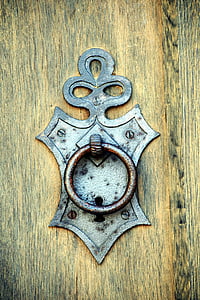 silver door knocker on brown wooden door thumbnail