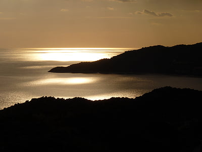 silhouette of a land form beside gray body of water thumbnail