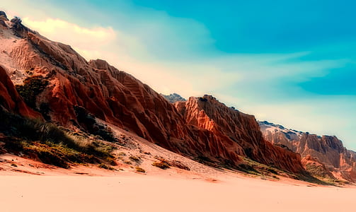 brown and orange rock mountain under clear sky thumbnail