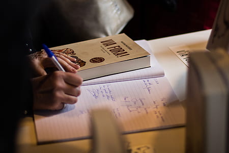 person writing on white lined paper thumbnail