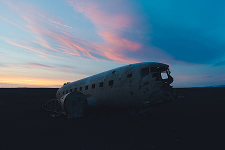 wrecked white plane under blue and pink sky thumbnail