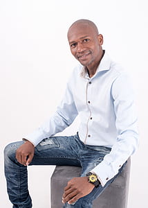 man in white dress shirt sitting on futon thumbnail