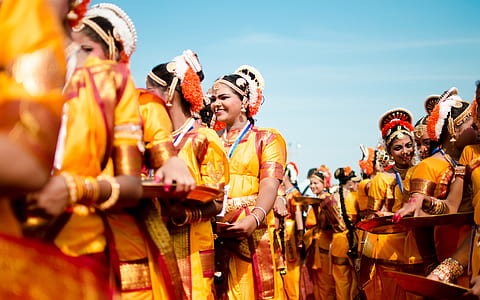 selective focus photography of parading women wearing dresses under clear blue sky thumbnail