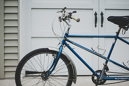 closeup photo of blue bike parked near white wooden door \ thumbnail