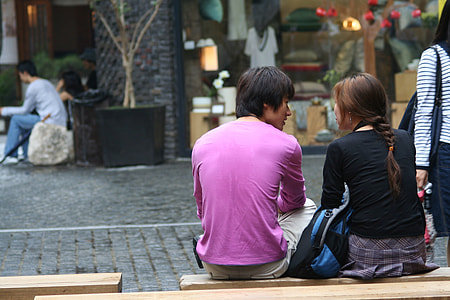 man and woman sitting on bench thumbnail
