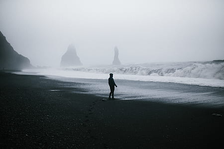man standing on seashore during daytime thumbnail