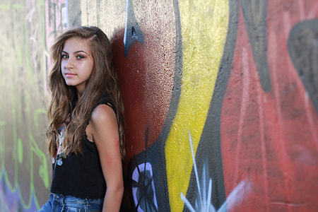 woman wearing black tank top leaning on wall thumbnail