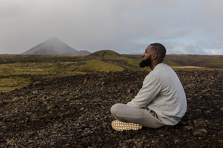 Man in White Top Sitting on Brown Soil thumbnail