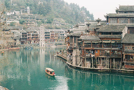 brown sailing boat near wooden houses thumbnail