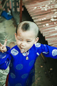 kid wearing blue Asian traditional coat thumbnail