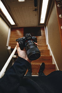 person holding black Sony DSLR camera thumbnail