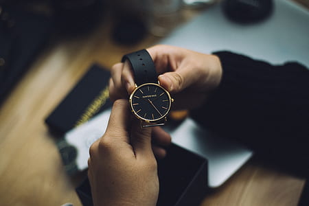 person holding round gold-colored analog watch thumbnail