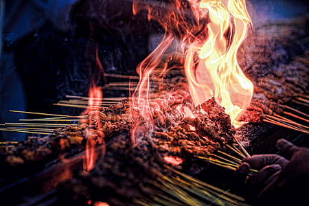selective focus photography of skewered meat being cooked on grill thumbnail