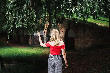 woman standing under green tree thumbnail