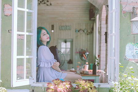 woman with green hair sitting on a window thumbnail