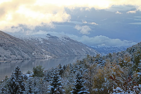 body of water between hills at daytime thumbnail