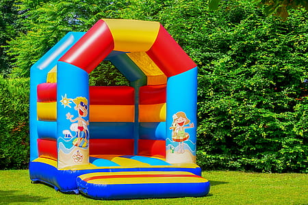 multicolored bounce house in front of trees thumbnail